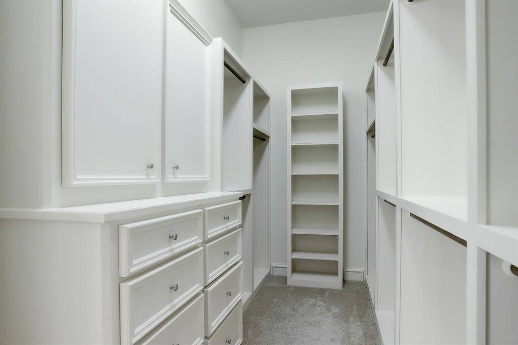 Two of two walk-in closets in primary bath.
