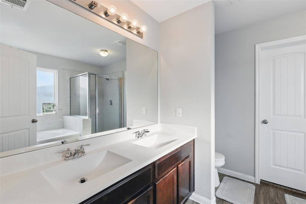 The primary bathroom has dual sinks, walk-in shower, and separate tub.