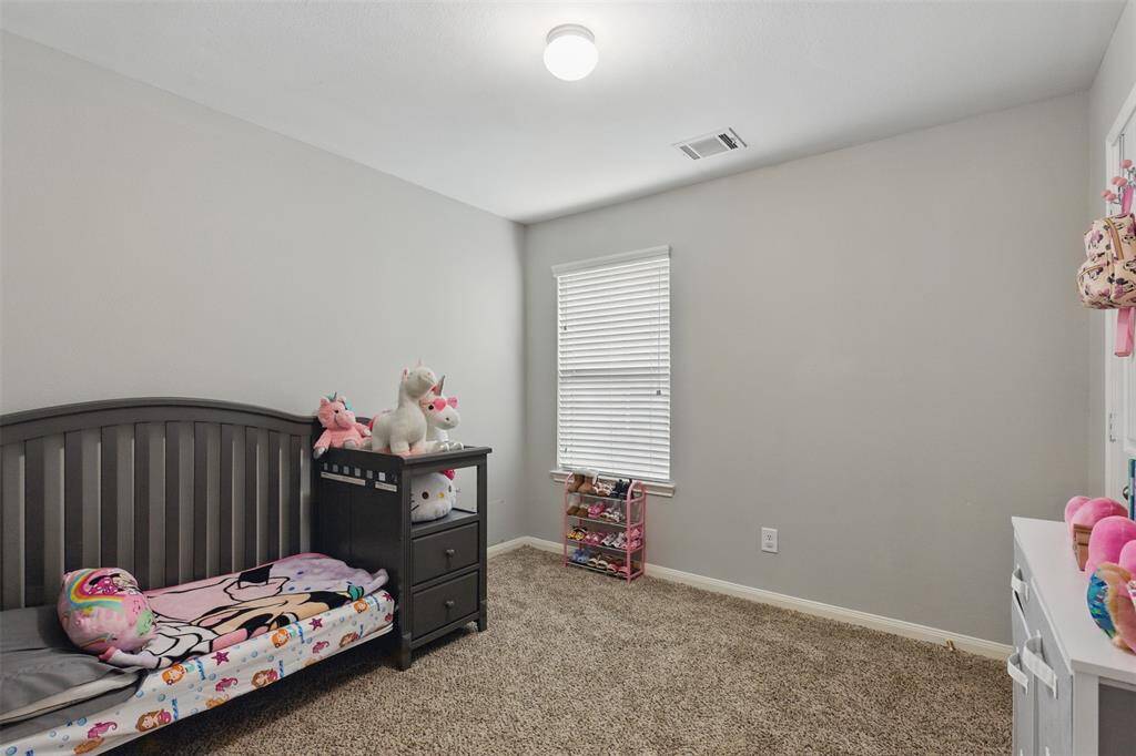 Secondary bedroom features awindow and plush carpet.