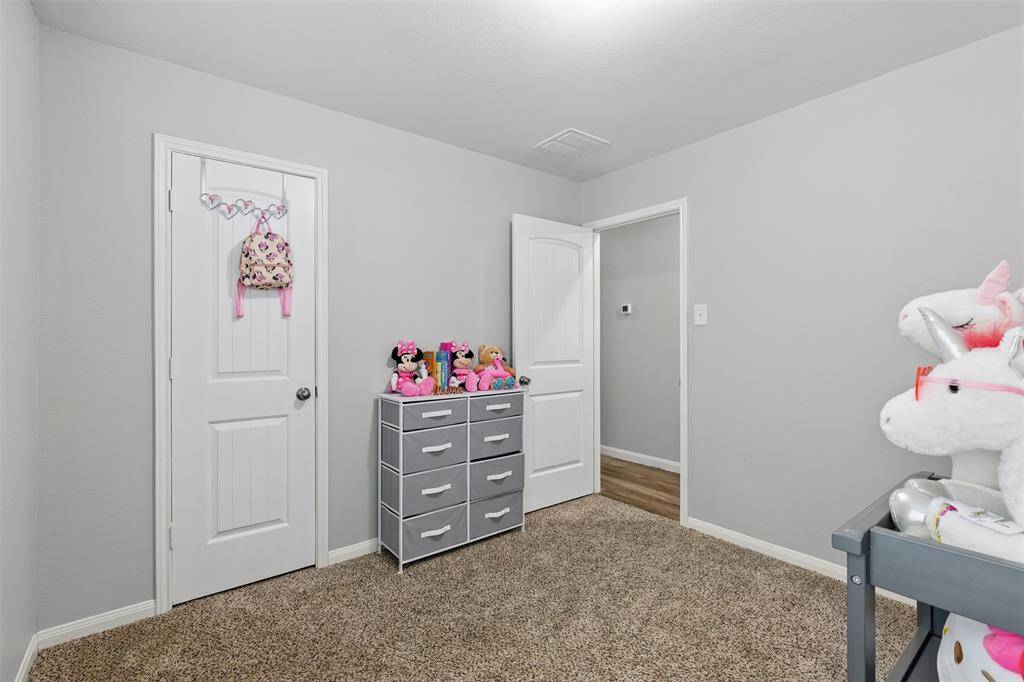 Secondary bedroom features awindow and plush carpet.