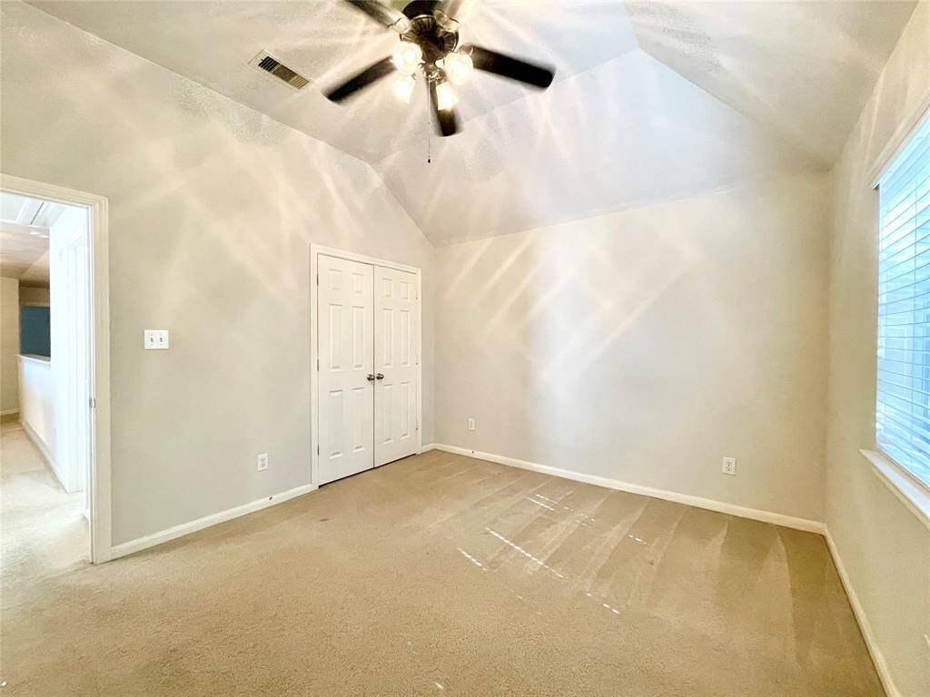 Bedroom #2 with a vaulted ceiling, a ceiling fan, and a double-door closet.