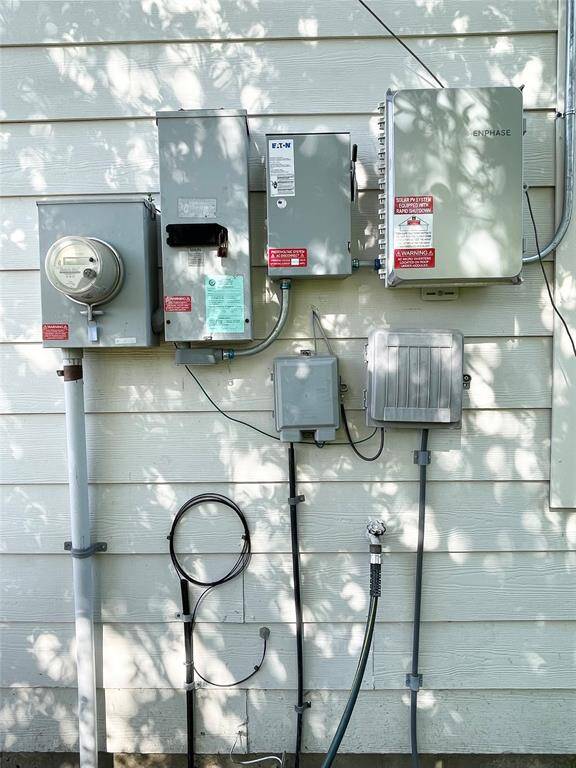 Array of utility boxes, including an electric meter, circuit breaker panel, communication boxes and inverter for Solar Energy System.