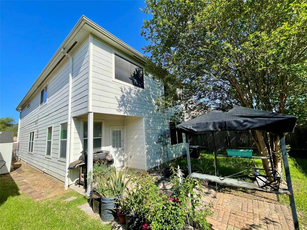 Backyard with a tree provides shade, and the yard is fenced, offering a cozy outdoor space.