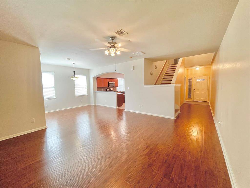 This spacious living area features hardwood floors, neutral walls, and ample natural light.