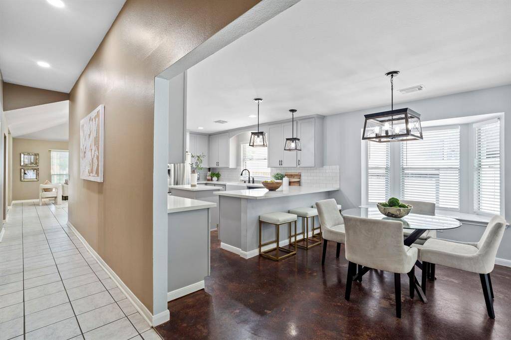 This updated kitchen blends function and style with a large peninsula, casual dining nook, and designer pendant lighting throughout.