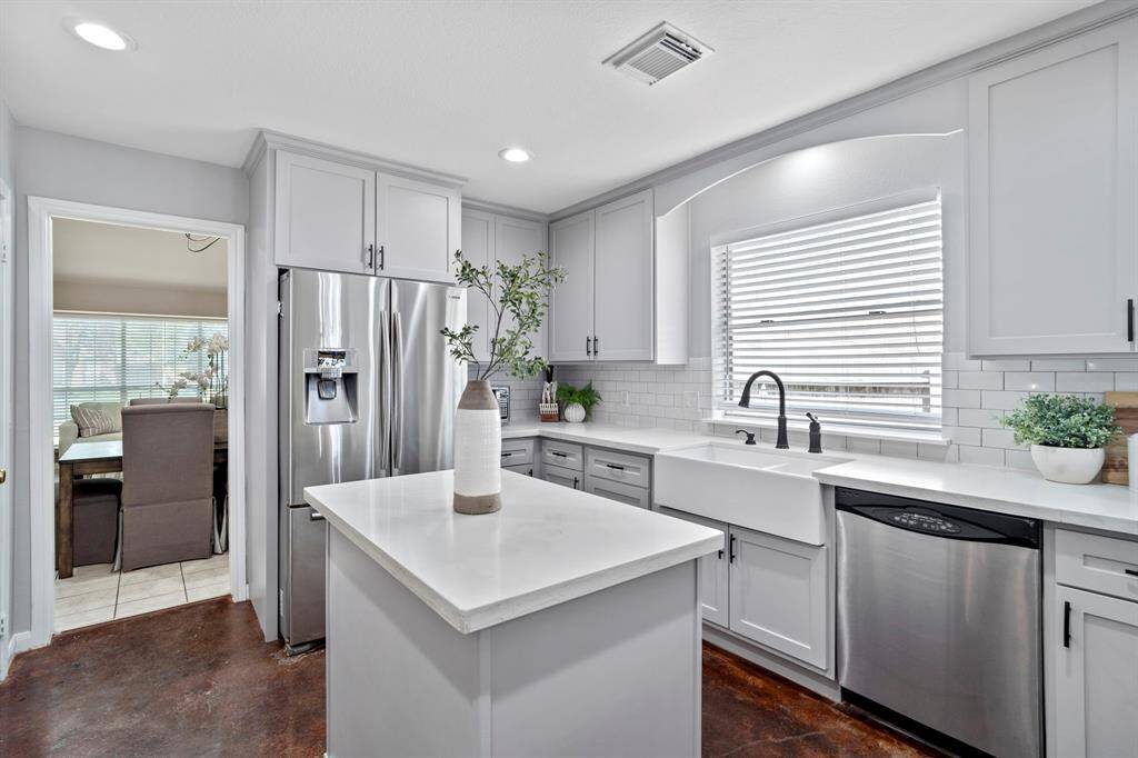 Crisp white countertops, modern hardware, and plenty of natural light make this kitchen as enjoyable to look at as it is to cook in.