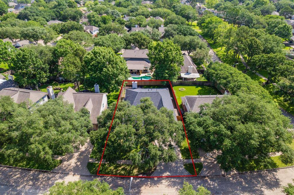 Nestled beneath a canopy of mature trees, this charming home sits on a spacious lot in Cinco Ranch Meadow Place, offering privacy and curb appeal in a quiet residential setting.