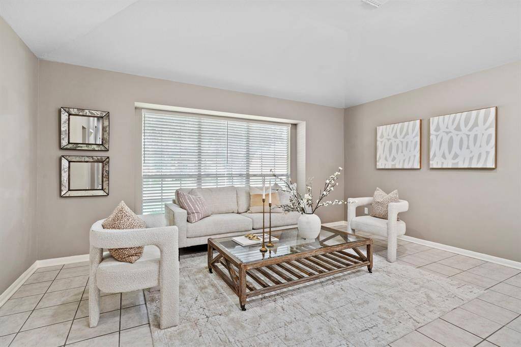 A large picture window fills the formal living room with soft natural light, creating a bright and welcoming atmosphere.