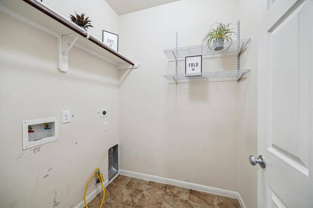 Efficient utility room with shelving and ample space for appliances, perfect for laundry and storage.