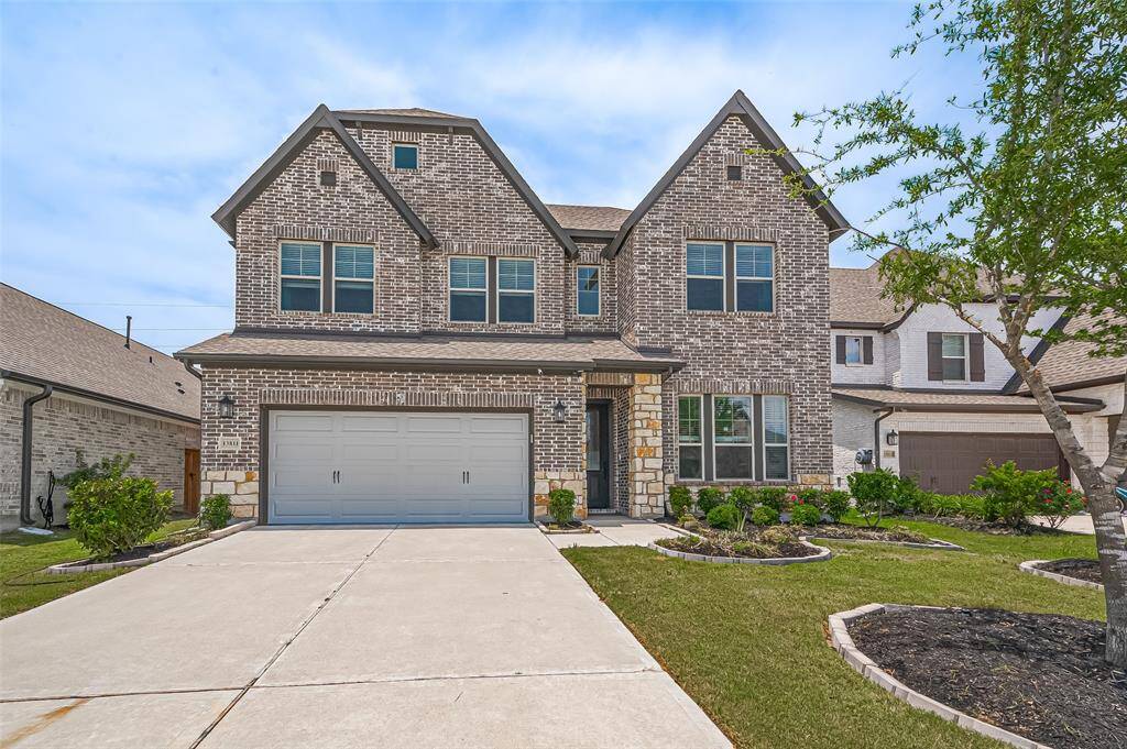 Stunning curb appeal with a classic brick and stone facade in a quiet Cypress neighborhood.