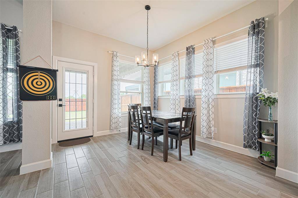 Charming dining area surrounded by windows, offering a bright and cozy space for family meals with views of the backyard.