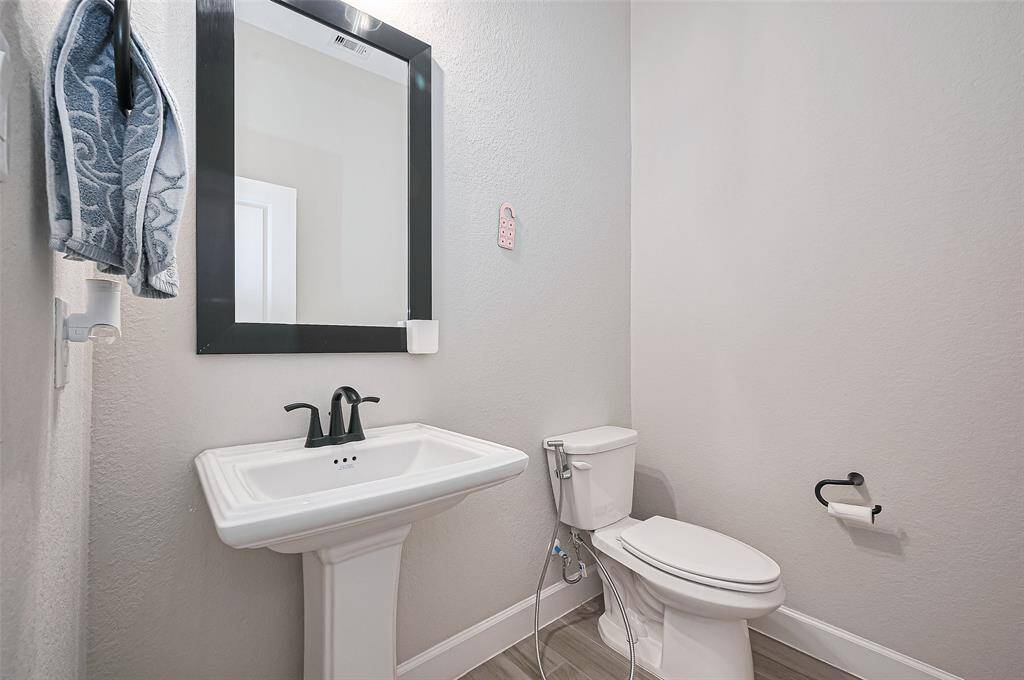 The conveniently located powder room offers a stylish and private space for guests, with a clean design blend seamlessly