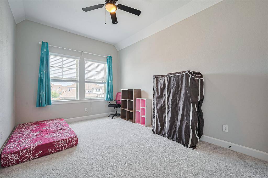 This well-appointed secondary bedroom features plush carpeting, a large window for natural light