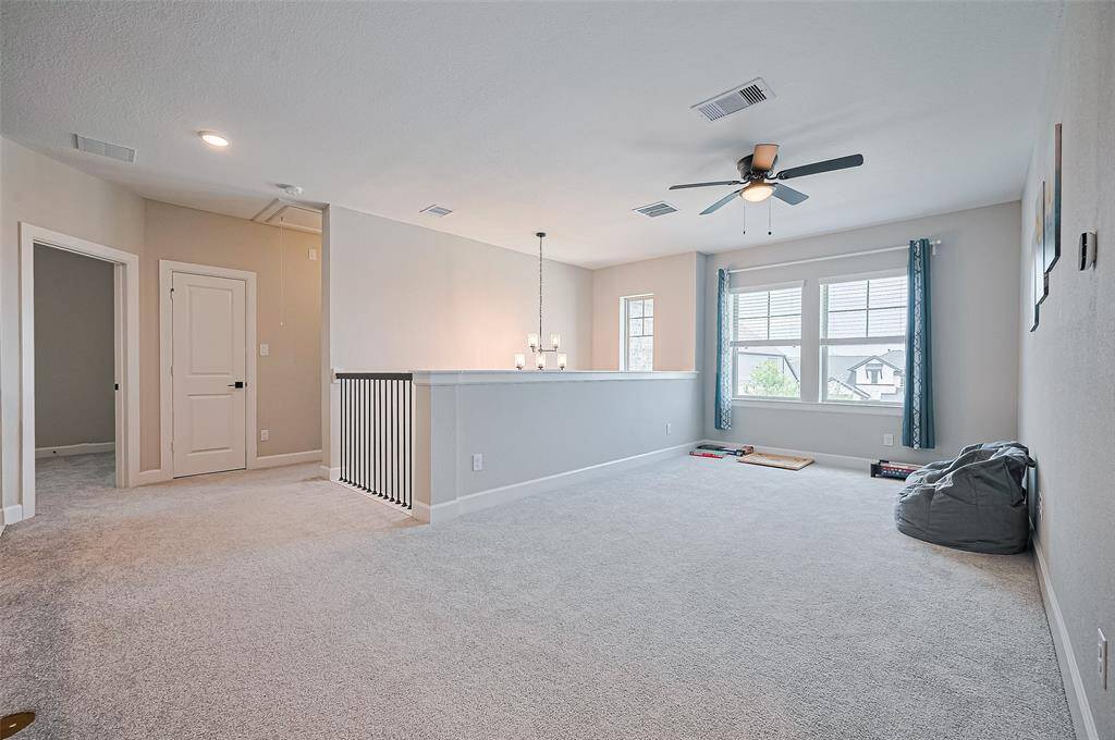 Extended view of the upstairs game room showcasing spacious layout, natural light, and modern finishes—designed for both leisure and functionality