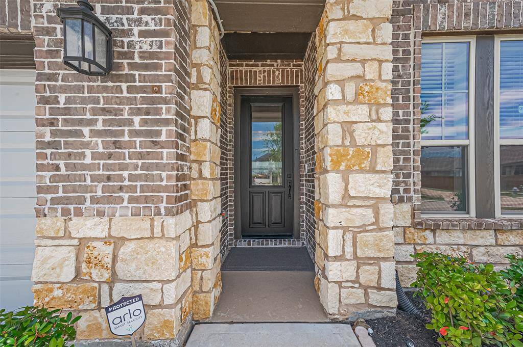The entryway features a charming brick and stone facade that adds warmth and character, setting a timeless tone as you step into the home