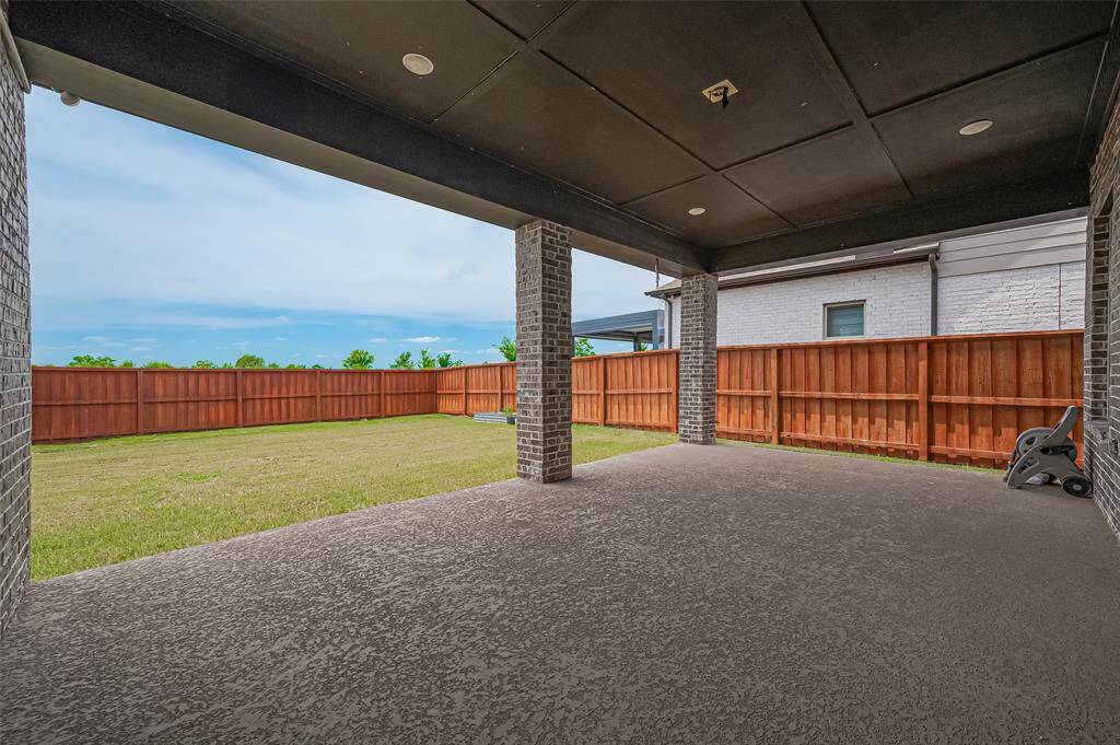 The covered patio is perfect for entertaining or relaxing year-round, while the lush green lawn provides ample space for kids, pets, or future landscaping projects