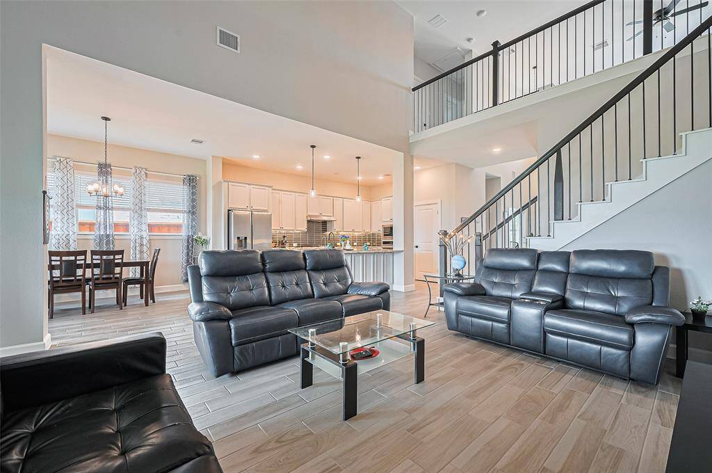 Expansive living room with soaring ceilings, large windows for natural light, and open access to the kitchen and dining—perfect for entertaining