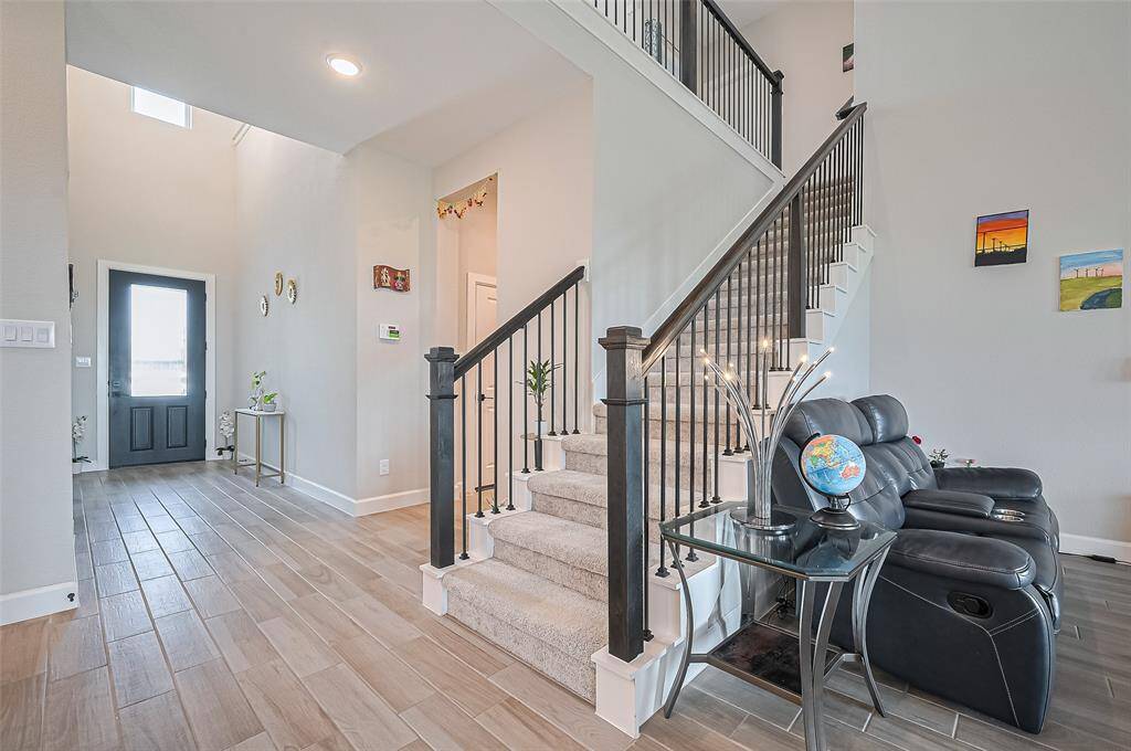 Welcoming entryway with wood-look tile flooring and elegant wall accents