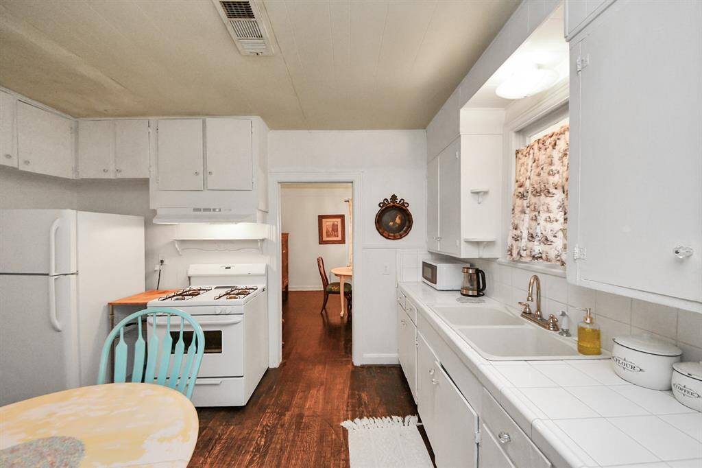A desirable gas cooktop range and ample space for a refrigerator complete this functional kitchen. The dining room is easily accessible through the doorway.