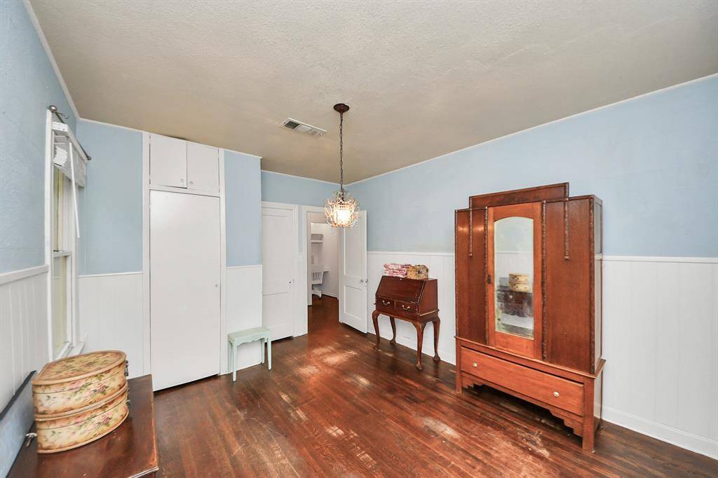 One of two sizable bedrooms, showcasing original wood floors and plenty of room to create your own personal retreat.