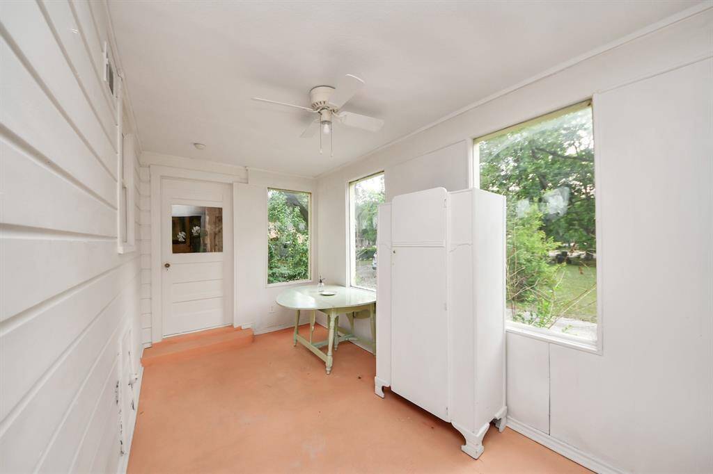 A sunroom perfect for reading, enjoying coffee or tea, or unwinding with a glass of wine. With windows to peek out and soak in the views, it is a peaceful retreat in this historic home.