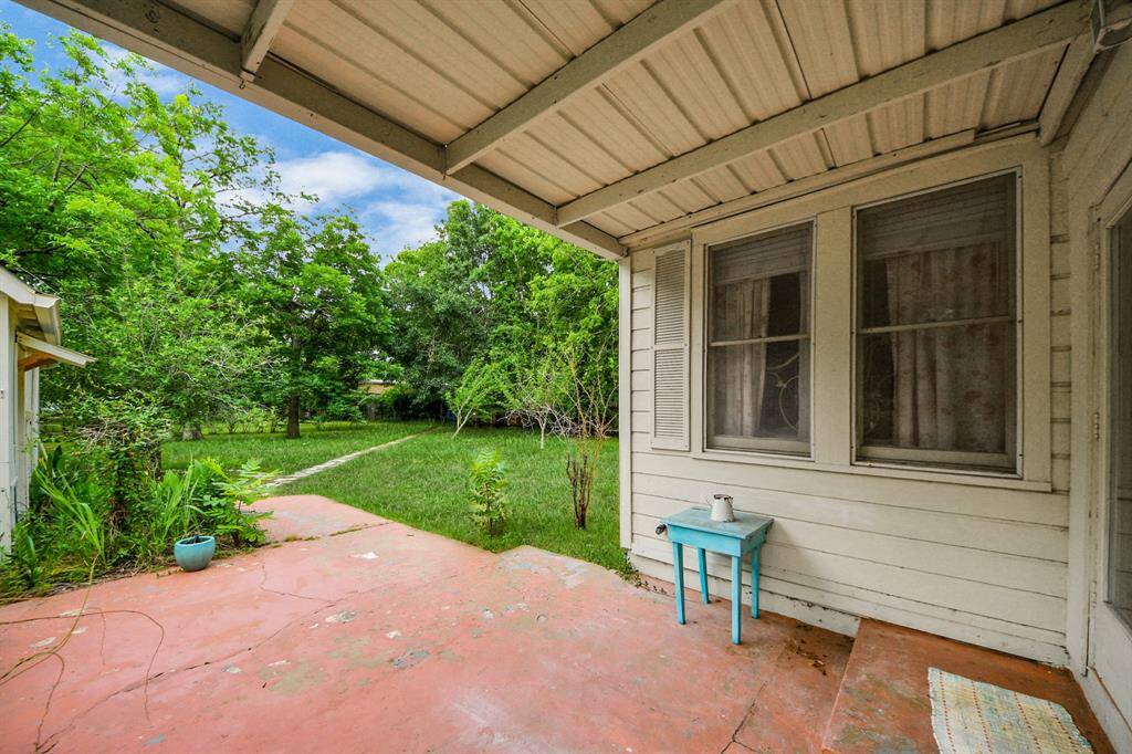 A covered back patio offers a shaded spot and leads out to the expansive yard beyond—perfect for outdoor living and play.