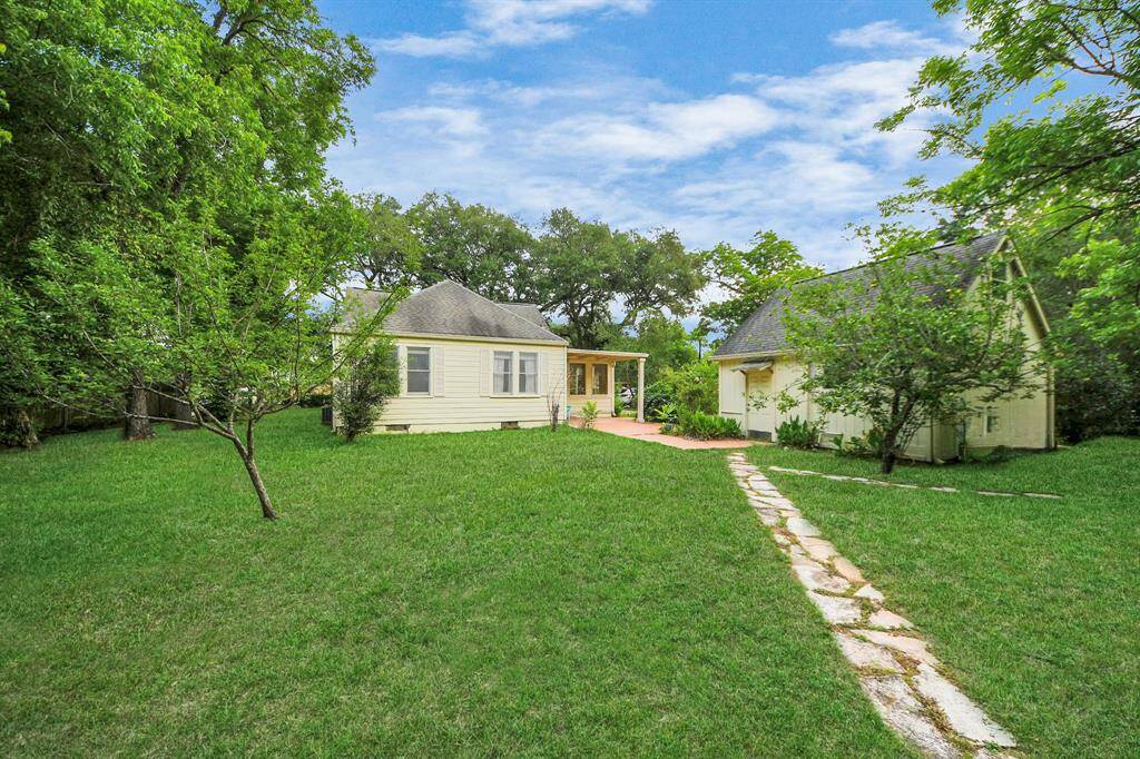 A charming flagstone walkway winds through the backyard, inviting you to explore and enjoy the spacious outdoor setting.