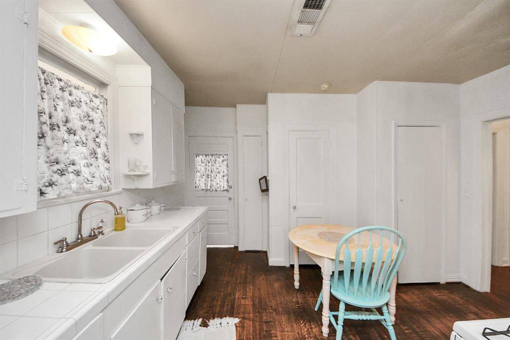 This adorable kitchen blends bright white cabinets with warm, contrasting wood floors for a fresh yet inviting look. This kitchen is ready for everyday meals and special recipes.