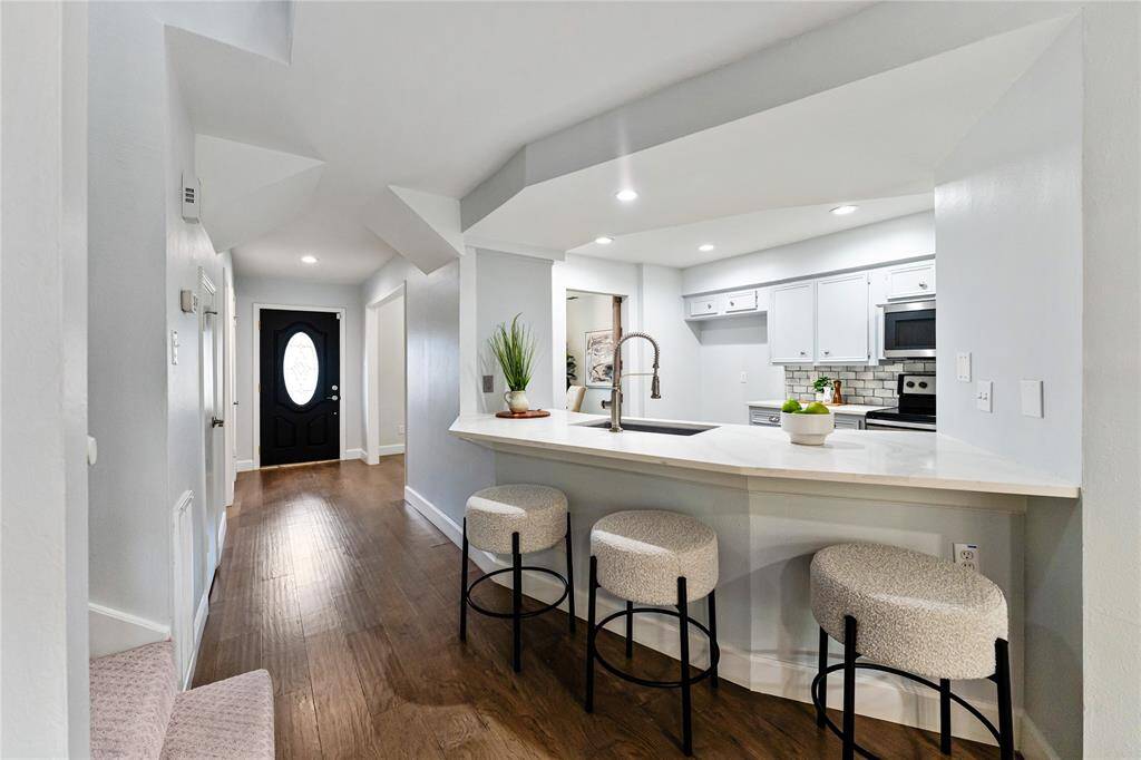 The open-concept kitchen has a sleek island and bar seating.