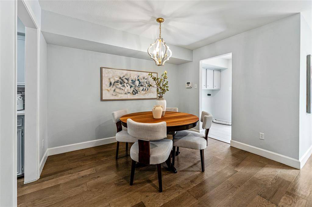 The dining area features a modern chandelier and it's open to the living room.
