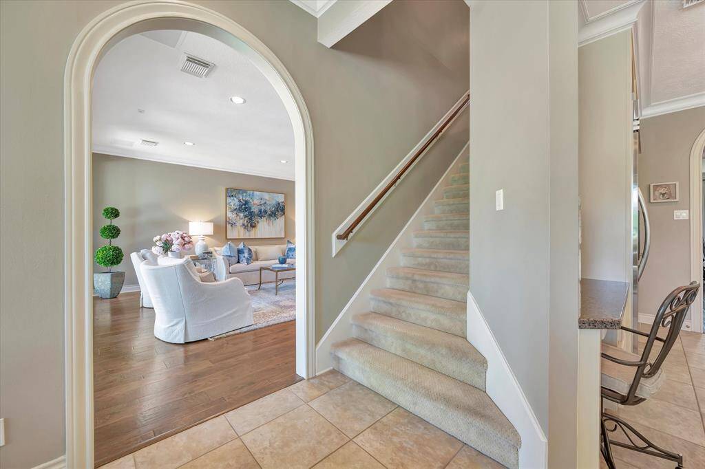 Dual staircase leading to upstairs secondary rooms and entertainment area. Architecturally designed arch entry into living room.