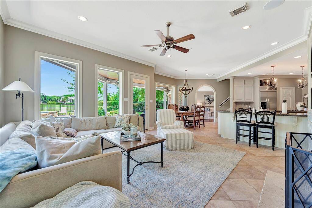 Walls of windows accent family room showcasing backyard views. Breakfast bar can hold several barstools.