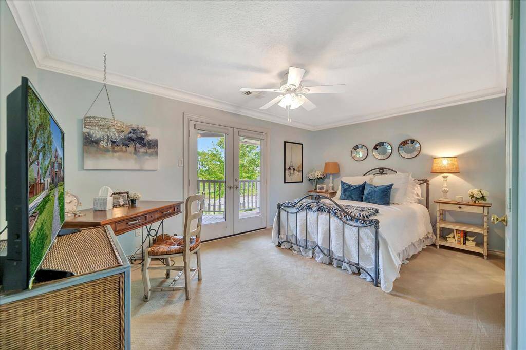 This cozy bedroom features a comfortable bed, built-in shelves for display, a ceiling fan, and ample natural light. Ideal for relaxation and storage.