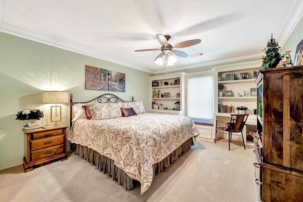 This garage is well-organized,  oversized with epoxy flooring and ample storage, including shelves, a workbench, and space for recreational equipment. It features a dartboard for leisure, a stainless steel fridge, and plenty of natural light through the door window, making it a versatile and functional space.