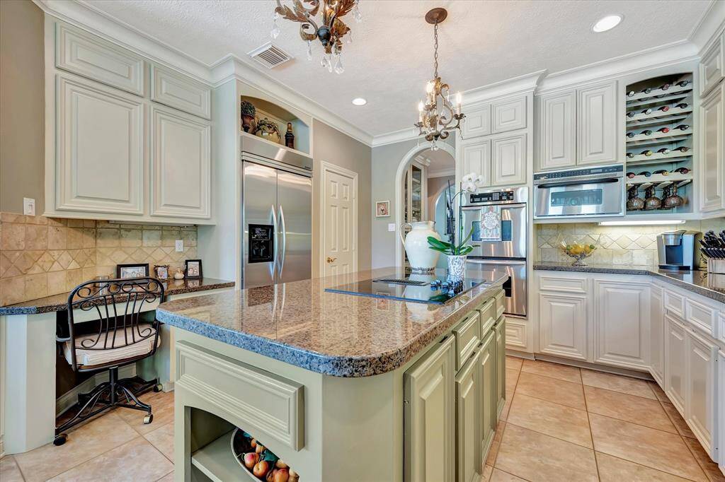 Tile backsplash and granite countertops. Built-in stainless steel refrigerator to remain with home. Double ovens. Built in microwave and wine rack. Under counter lighting.wine rack