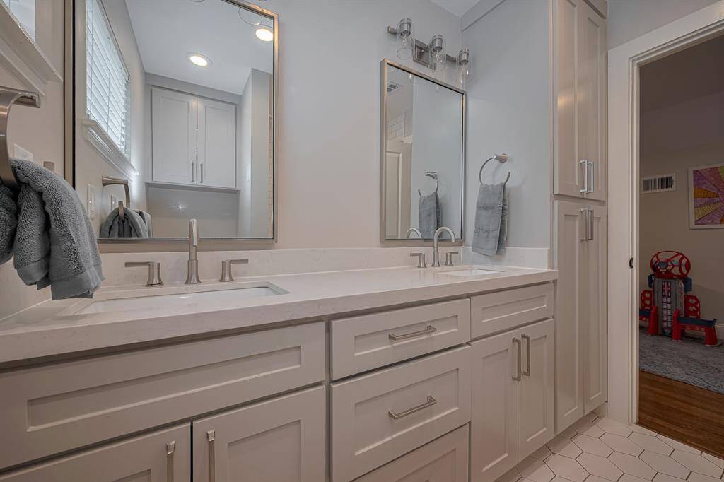 SECONDARY BATHROOM - Beautifully updated with dual sinks and a shower/tub combo.