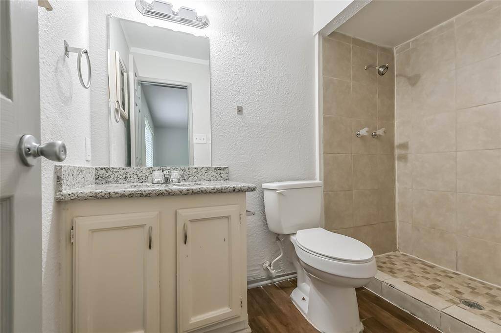 Primary bath has walk in shower with tile surround