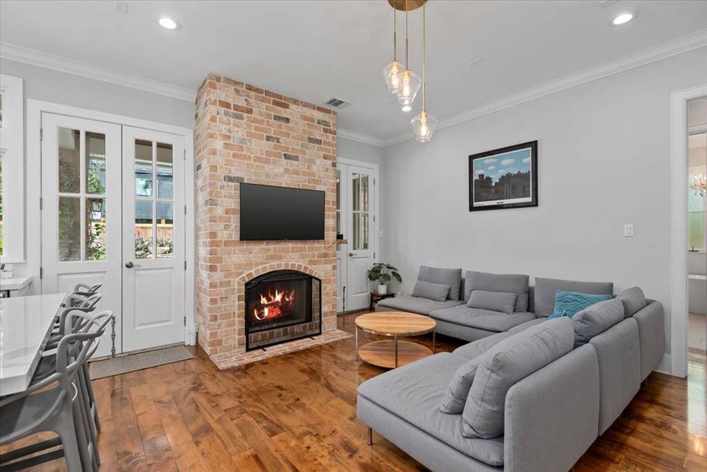 The living space is brightened by French doors leading to the outside, offering a warm, inviting atmosphere with hardwood floors throughout.