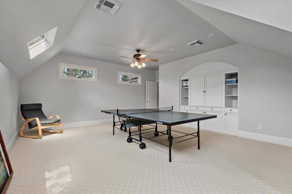 The extra large entertainment room (game, media, 5th bedroom) features built in cabinetry and and warm natural lighting.