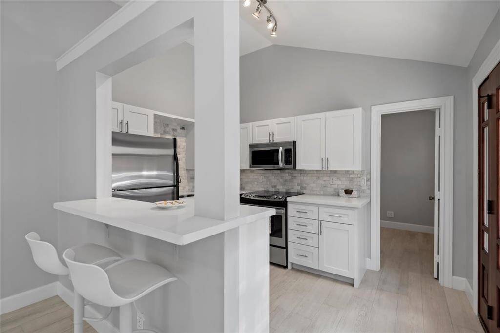 The elegant guest house kitchen offers quartz countertops and stainless steel appliances.