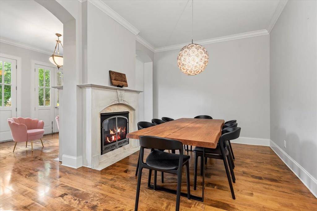 This elegant dining area features a cozy fireplace and a stylish pendant light.