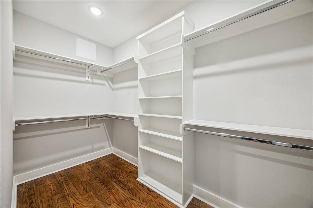 Enjoy abundant storage with this spacious walk-in closet featuring custom shelving and rods. The smart design maximizes space and organization, perfect for fashion lovers and organized living.