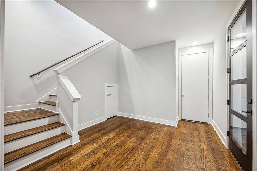 Step into this welcoming foyer with warm wood floors and clean architectural lines. The open stairway sets the tone for a sleek, modern layout, while the under-stairs storage adds practical functionality. Light-filled and crisp, this space is the perfect entry point to a beautifully designed home.