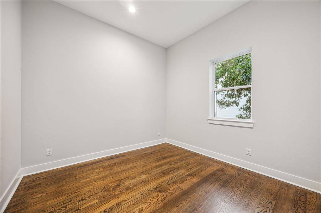 This cozy bedroom features soft, natural light filtering through the window. The sleek wooden floors and elegant lighting create a perfect blend of elegance and coziness, this bedroom invites restful nights.