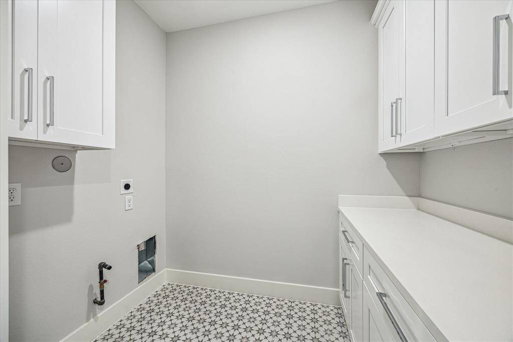 Laundry day just got a major upgrade. Custom cabinetry, expansive counters, and detailed tile flooring bring both form and function to this thoughtfully designed utility space.