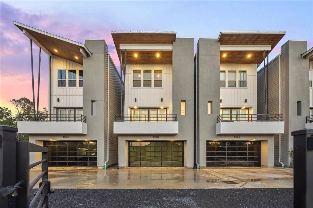 This stunning, modern townhome showcases an architectural masterpiece, combining sharp angles, expansive balconies, and large windows. The design emphasizes both privacy and openness, with each home offering its own balcony for outdoor enjoyment. The dramatic rooflines and carefully positioned exterior lights create an inviting and visually appealing facade, enhanced by the soft colors of the sunset sky as a backdrop.