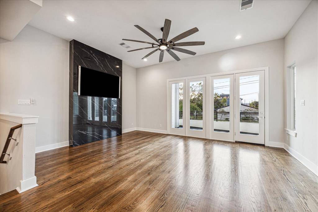 Bright, spacious, and thoughtfully designed, this living room opens seamlessly to the large balcony, inviting natural light and downtown views. The centerpiece, a sleek, black marble accent wall, adds a touch of luxury, perfectly complemented by a stylish ceiling fan, creating a harmonious blend of comfort and elegance in this open-concept space.