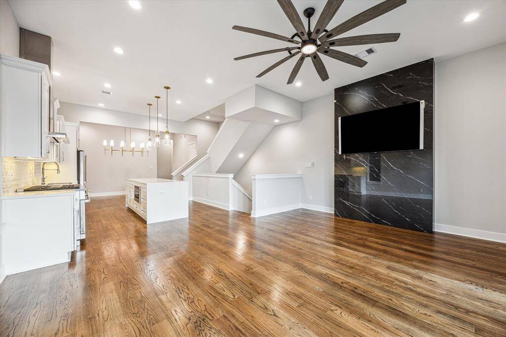 Entertain effortlessly in this expansive living area, complete with hardwood floors, a sophisticated chandelier, and plenty of room for gatherings. The layout flows from the kitchen to the dining space, making it an ideal setup for hosting or enjoying a quiet evening at home. Each detail, from lighting to finishes, exudes style and quality.