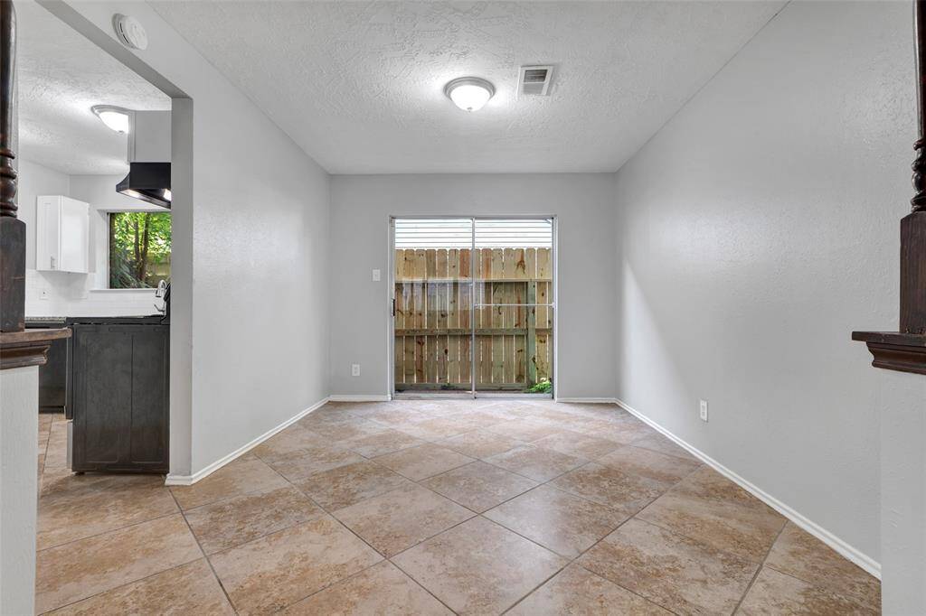 Beside the kitchen, is the dining area. It features a glass door that opens to the backyard, allowing easy access for outdoor meals and gatherings.