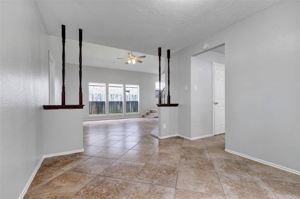 From the dining area, you get a clear view of the living space. To the right, an open door leads directly into the kitchen, creating a natural flow between rooms.